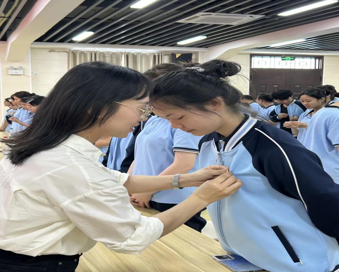6.团委副书记覃丽秋为新团员佩戴团徽